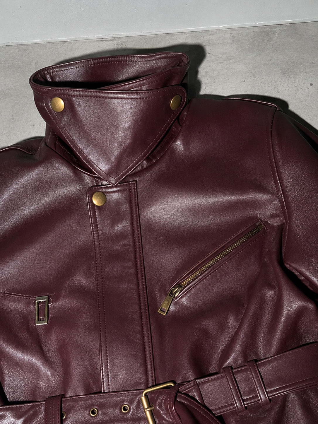 Women's Burgundy Faux Leather Belted Moto Jacket with High Funnel Neck — Macro Fabric Texture Detail